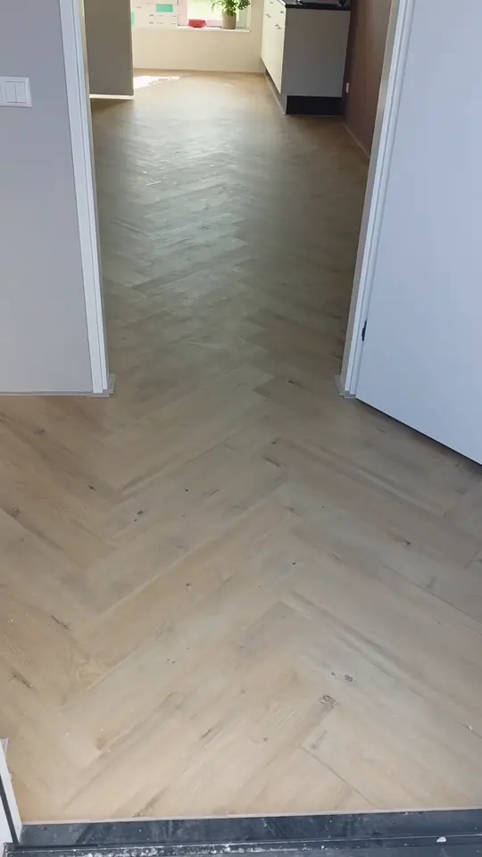 Afgewerkte visgraatvloer in een hal